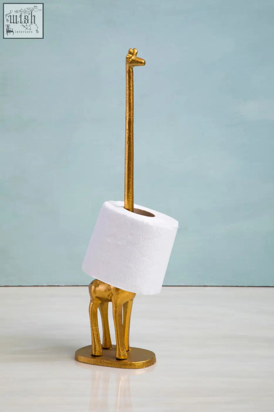 Fauna gold finish giraffe toilet roll holder with a gold-colored giraffe shape and white toilet roll on its neck