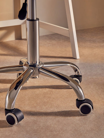 Chrome finished five star base with black caster wheels on a fayth grey velvet buttoned home office chair