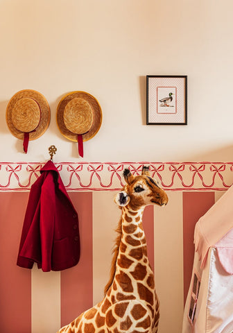 A plush giraffe figurine with tan and brown spots made of soft fabric in the feather and grace duck print iii collection