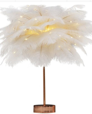 A white feather lamp with a golden base and warm led lights perfect for bedroom decoration with remote control and power supply
