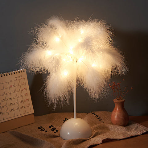 A soft white feather lamp with warm led lights glowing through fluffy plumes perfect for bedroom decoration
