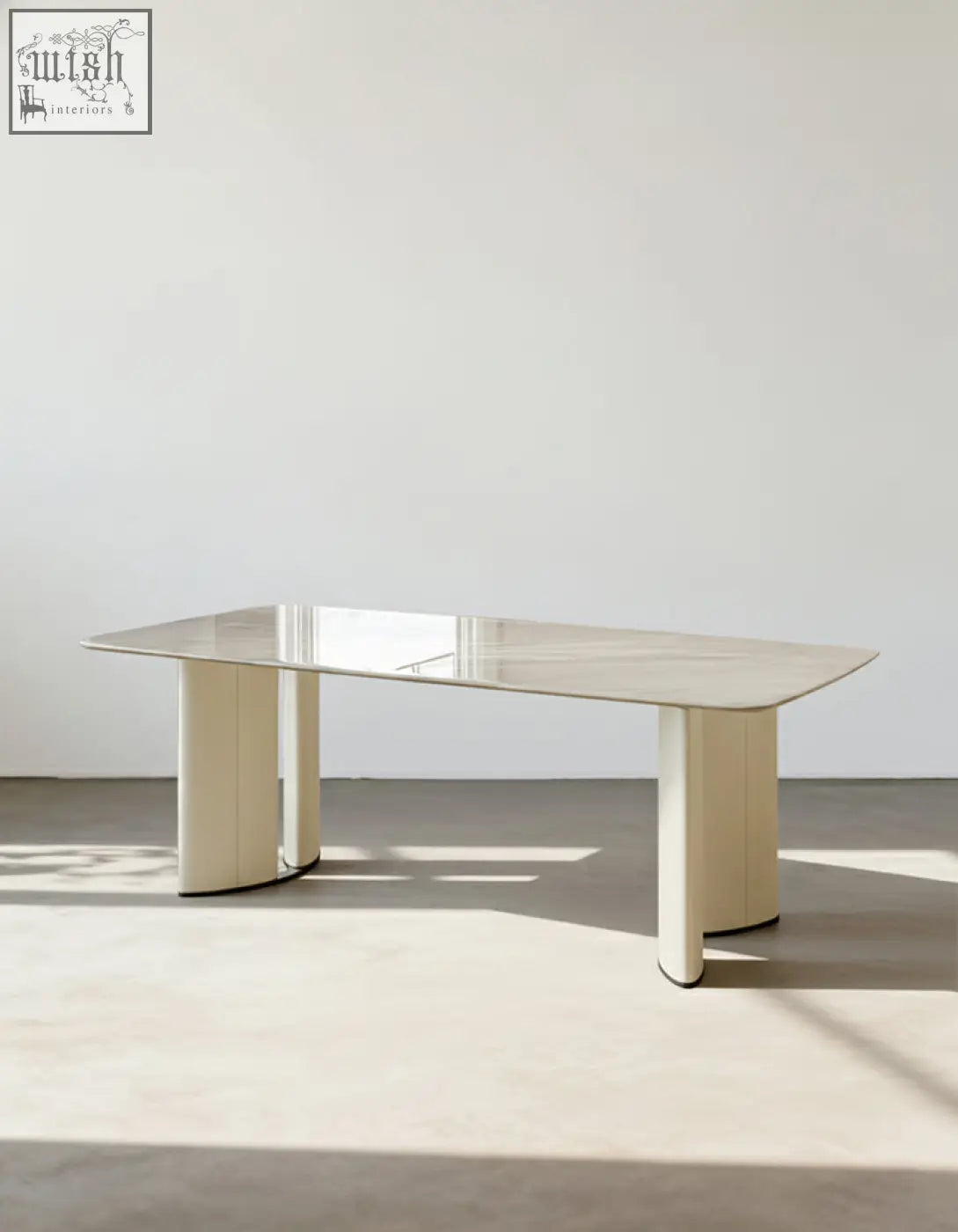 Felicia marble dining table with a sleek polished marble top and cream-colored cylindrical legs modern minimalist dining table