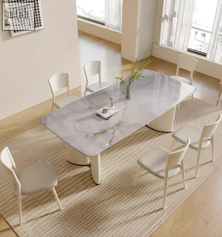 Modern felicia marble dining table with a white marble top and curved cream-colored legs for stylish dining spaces