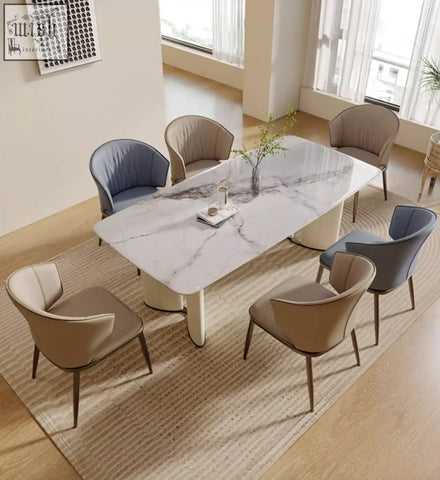 Modern felicia marble dining table with sleek white and gray veining and minimalist cream cylindrical legs