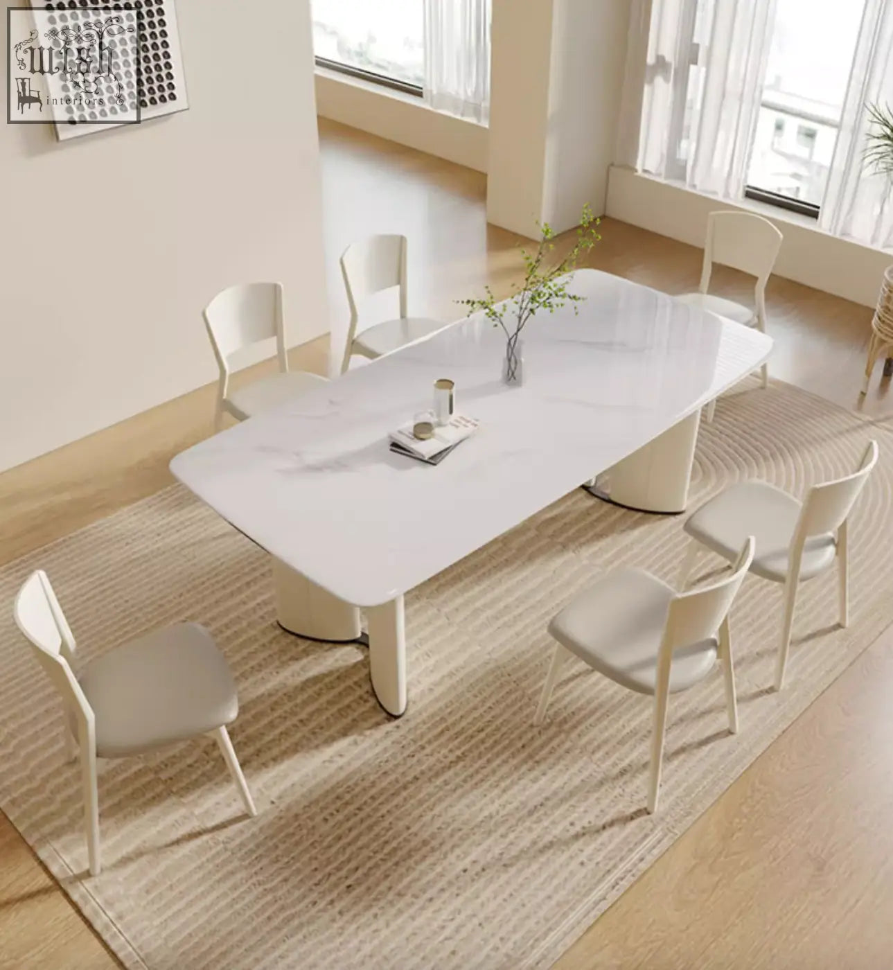 Modern white felicia marble dining table with sleek minimalist legs and central vase holding greenery