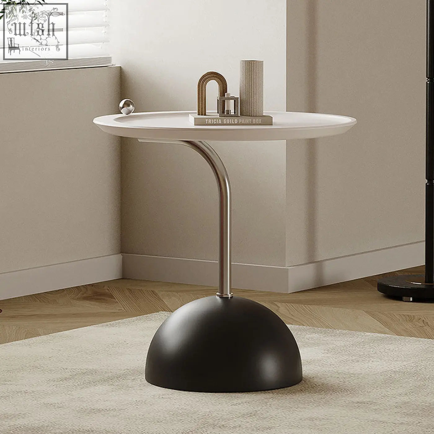 Felicia side table with modern white circular top and sleek metallic leg on a black base with piano baking varnish
