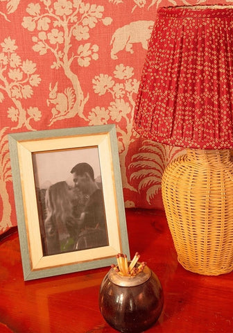 A ferrante marquetry frame 6x4 with a red pleated lampshade and woven wicker base in a marquetry frame style