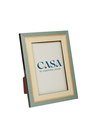 A sleek light green wooden ferrante marquetry frame 6x4 with a cream inner border and casa by josephine jenno logo