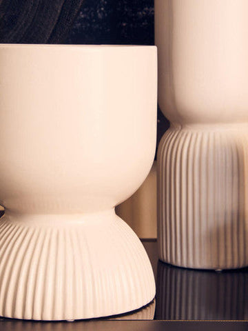 Cream-colored ceramic fia white planter with fluted ribbed base and smooth rounded body white planter design