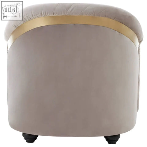 A plush fifi grey velvet ottoman with quilted top and sleek gold band complements the grey velvet chair collection