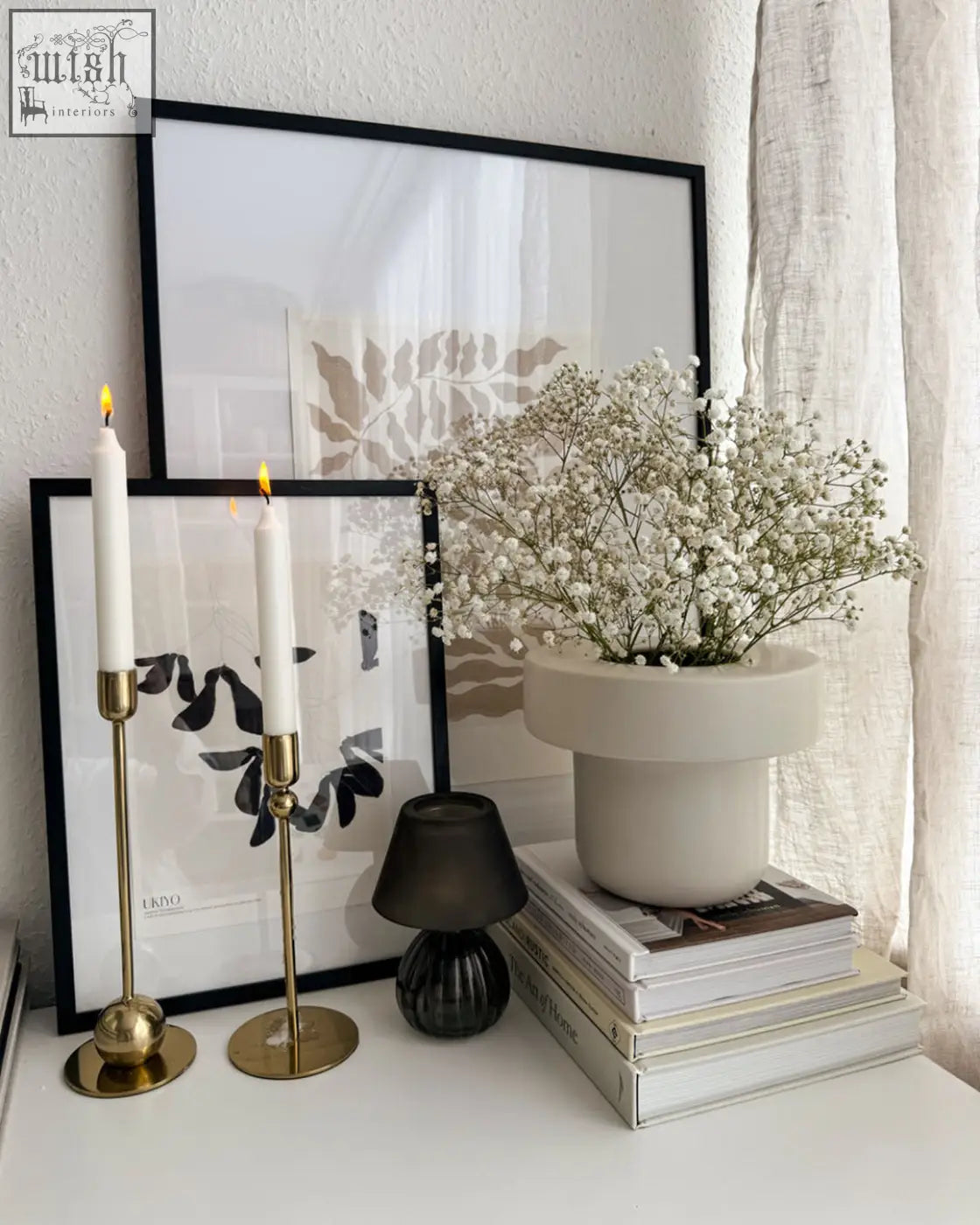 Fika nature art print beside a sleek off-white ceramic planter with modern two-tier design holding white baby’s breath flowers