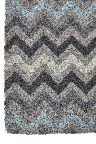 A plush shaggy area rug with a bold white chevron pattern in shades of gray and muted blue perfect for home decor