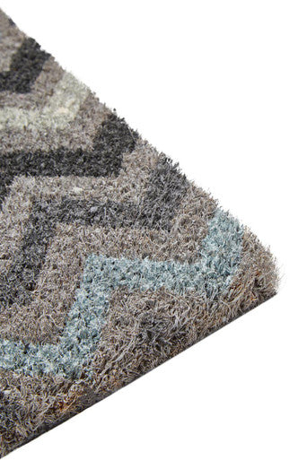 A plush shaggy rug with a gray and muted blue zigzag pattern matching the white chevron style coir doormat
