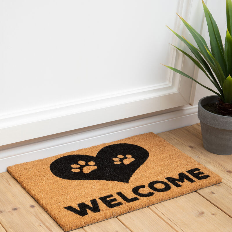 A tan coir filta paw heart doormat with a black heart, two paw prints, and bold welcome text