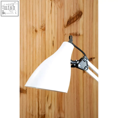 Finley white adjustable desk lamp with white conical shade and black metal joints mounted on wooden background