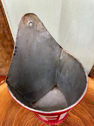 Red and silver metal fire plant pot planter with worn rustic finish used as letter tidy and kindling holder