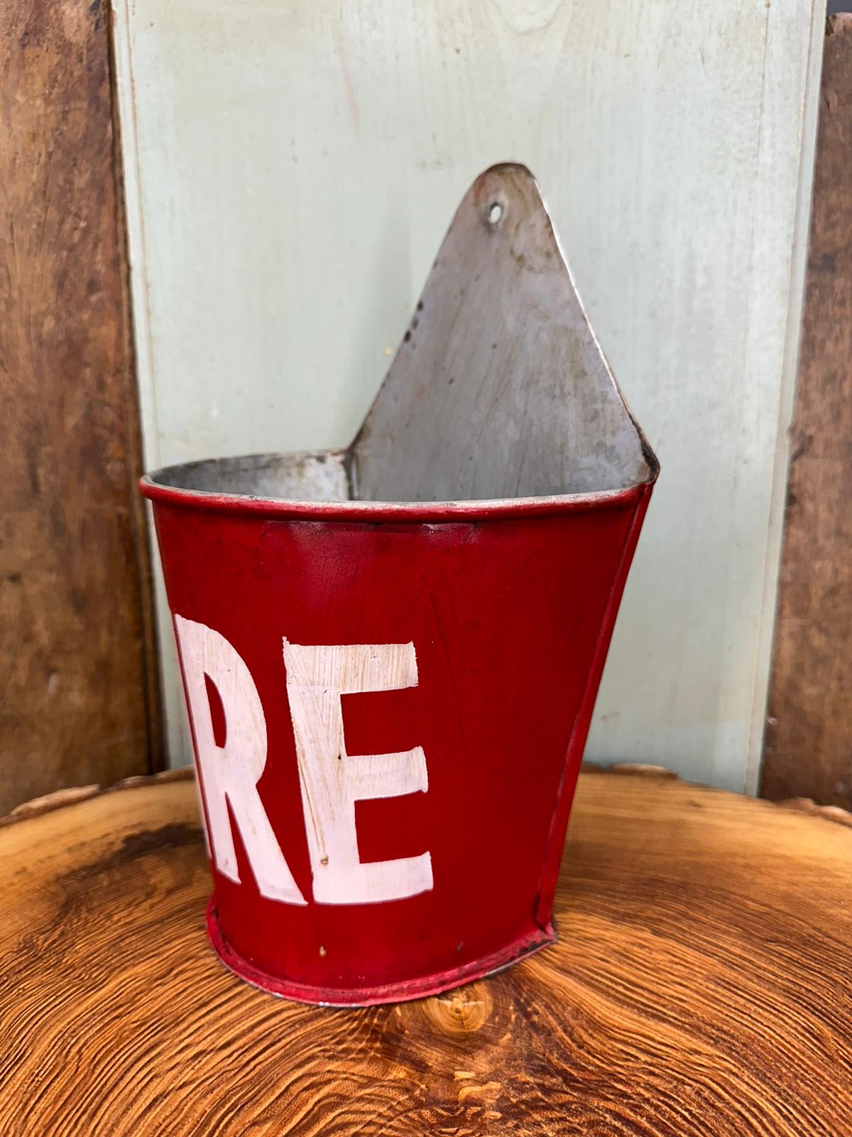 Red metal fire bucket with white lettering and hanging loop used as fire plant pot planter and kindling matches holder