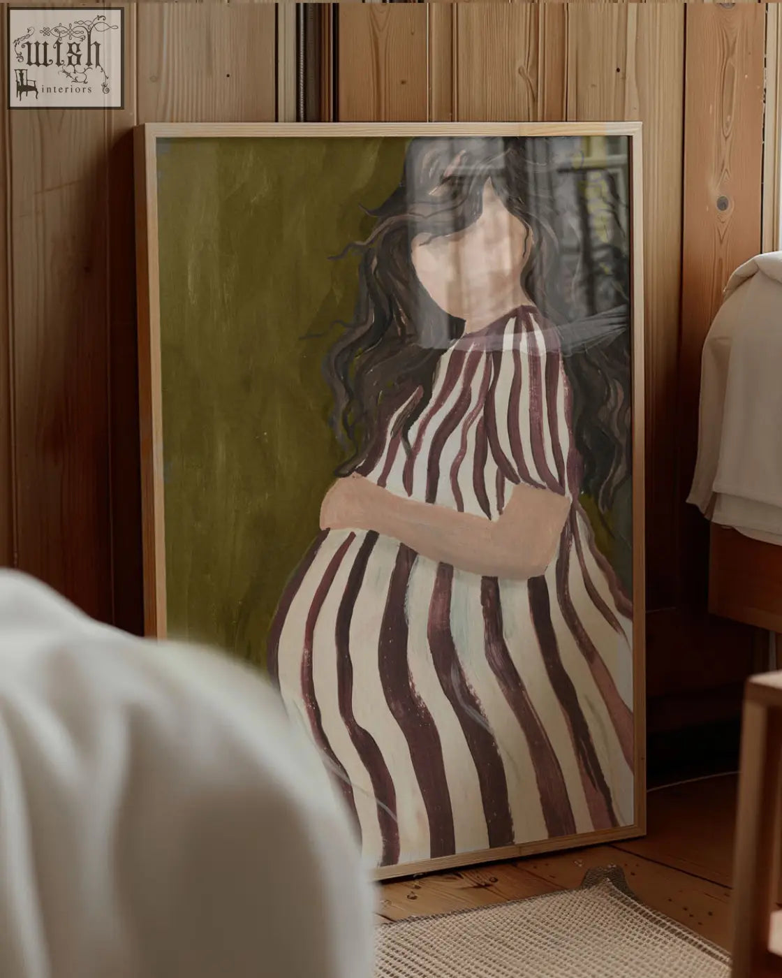 Framed parenthood art print of a pregnant woman in a white and dark brown striped dress on olive green background