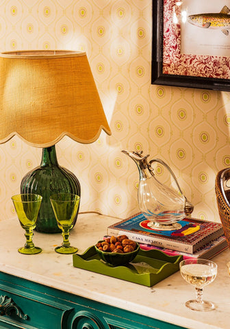 A dark green ribbed glass table lamp with a textured mustard yellow fabric shade perfect for cozy lighting