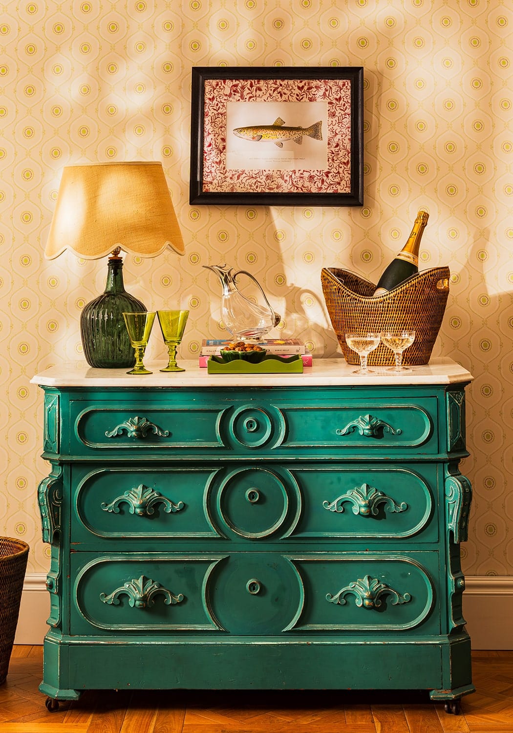 A teal green antique style dresser with ornate carved drawers and decorative handles in a fish ii framed print setting