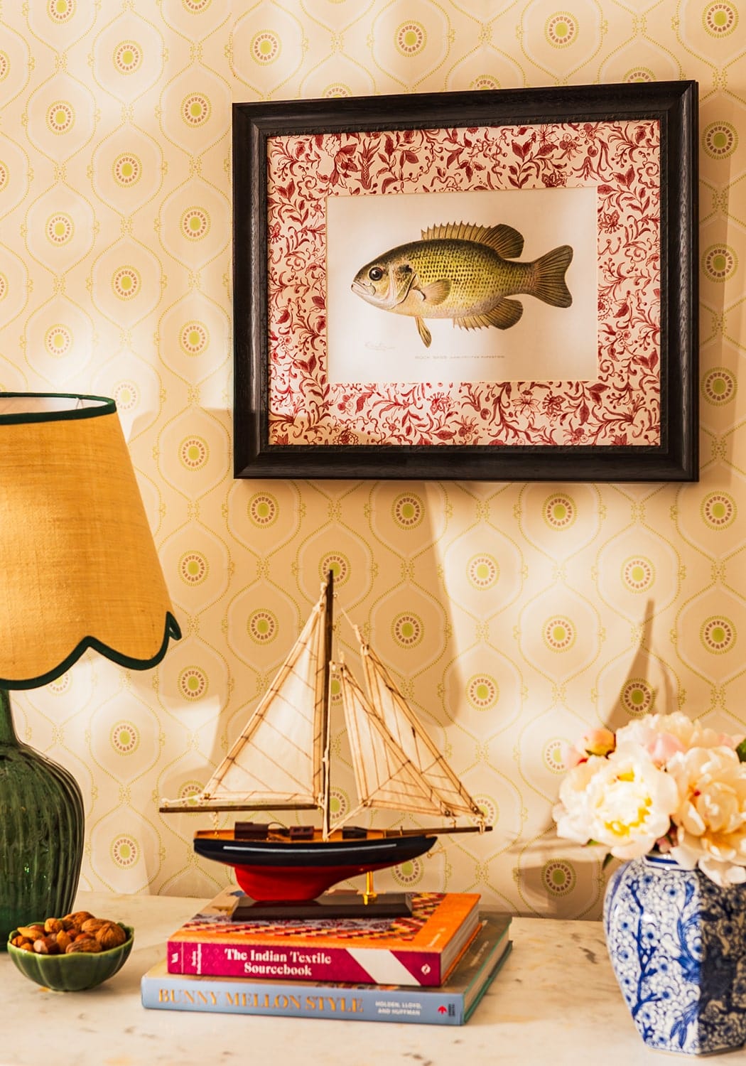 Framed print of a greenish brown fish illustration on red floral background in black frame by just a bit brilliant