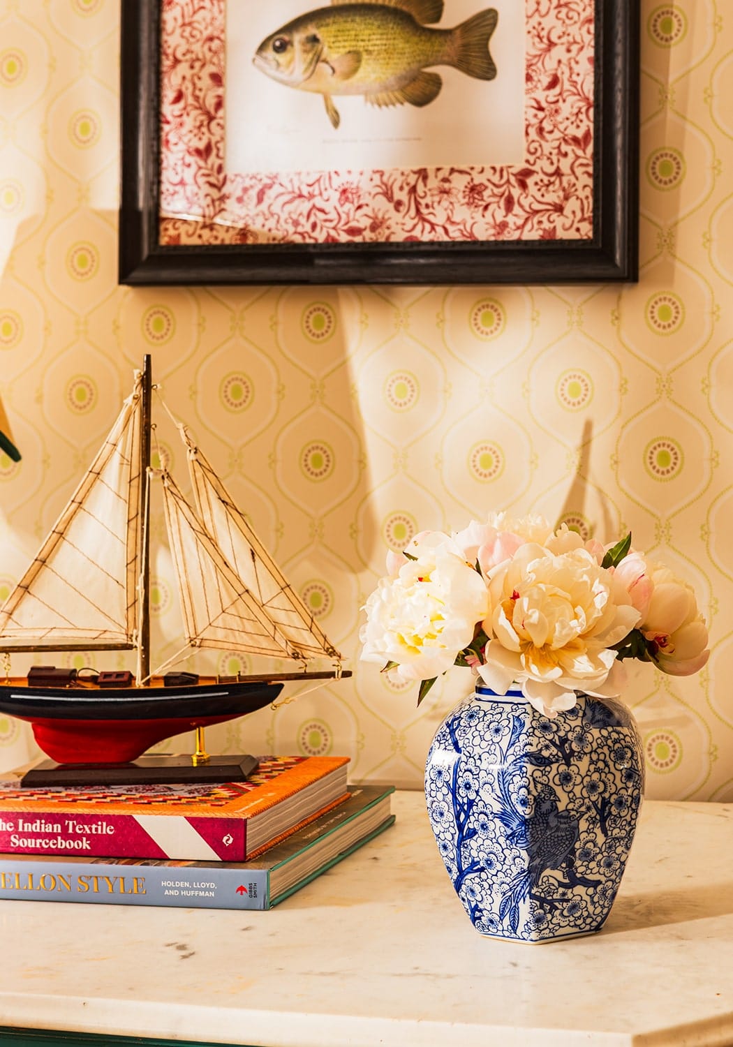 A blue and white porcelain vase with floral patterns holding pink and cream peonies in a fish iv framed print british
