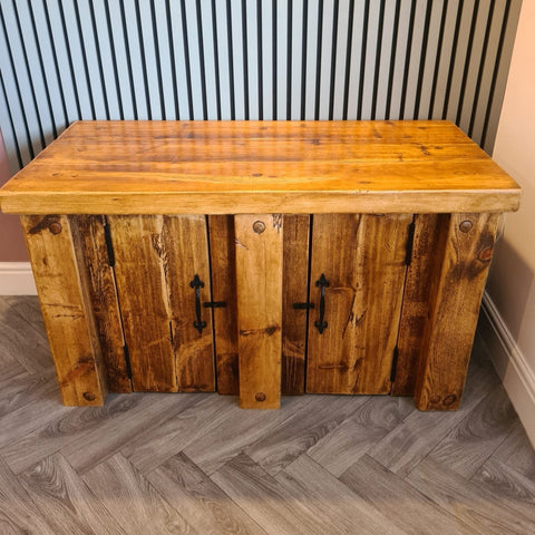Rustic wooden fish tank stand with warm redwood finish and black metal handles features two doors for storage