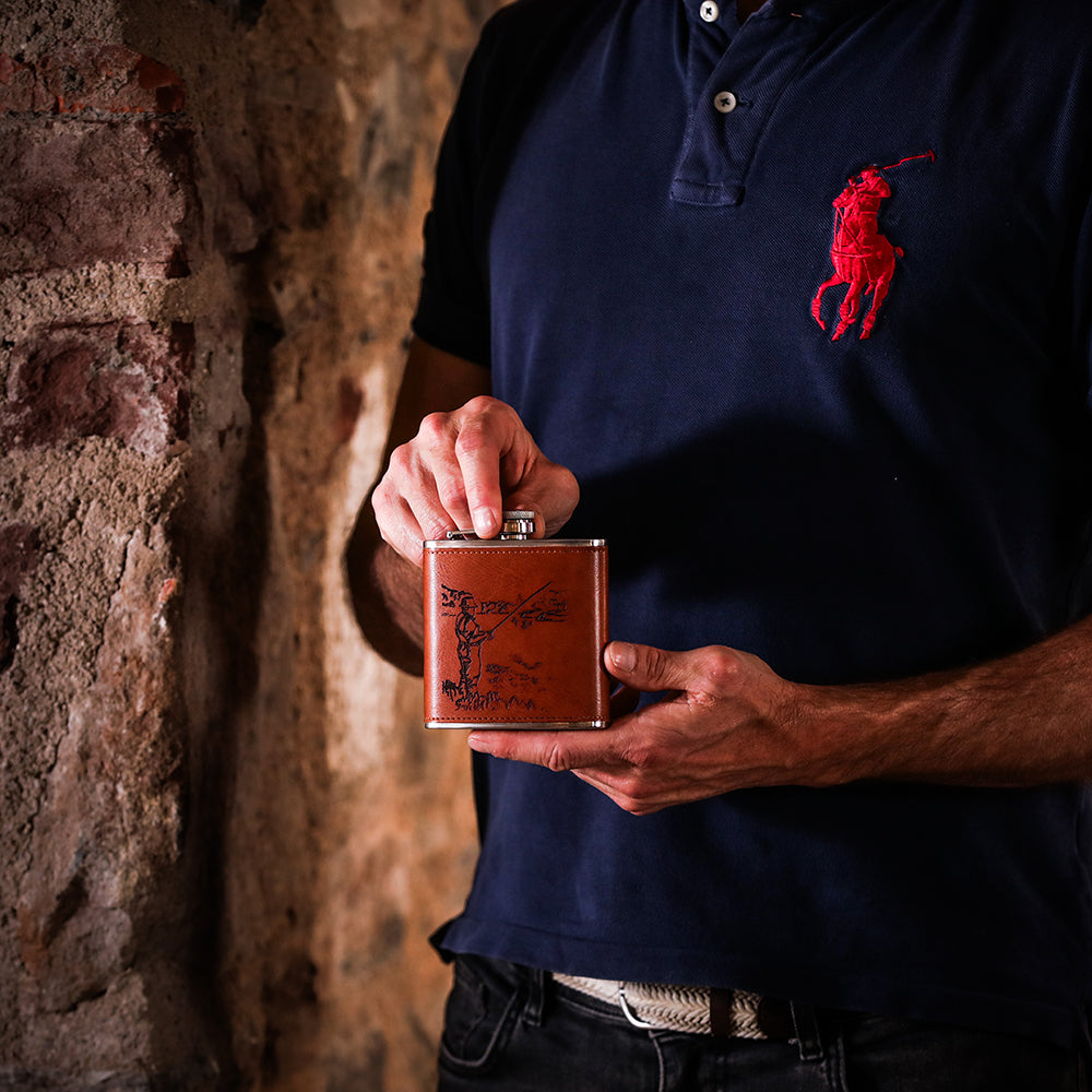 Brown leather hip flask with silver cap and engraved fishing man illustration perfect leather hip flask accessory