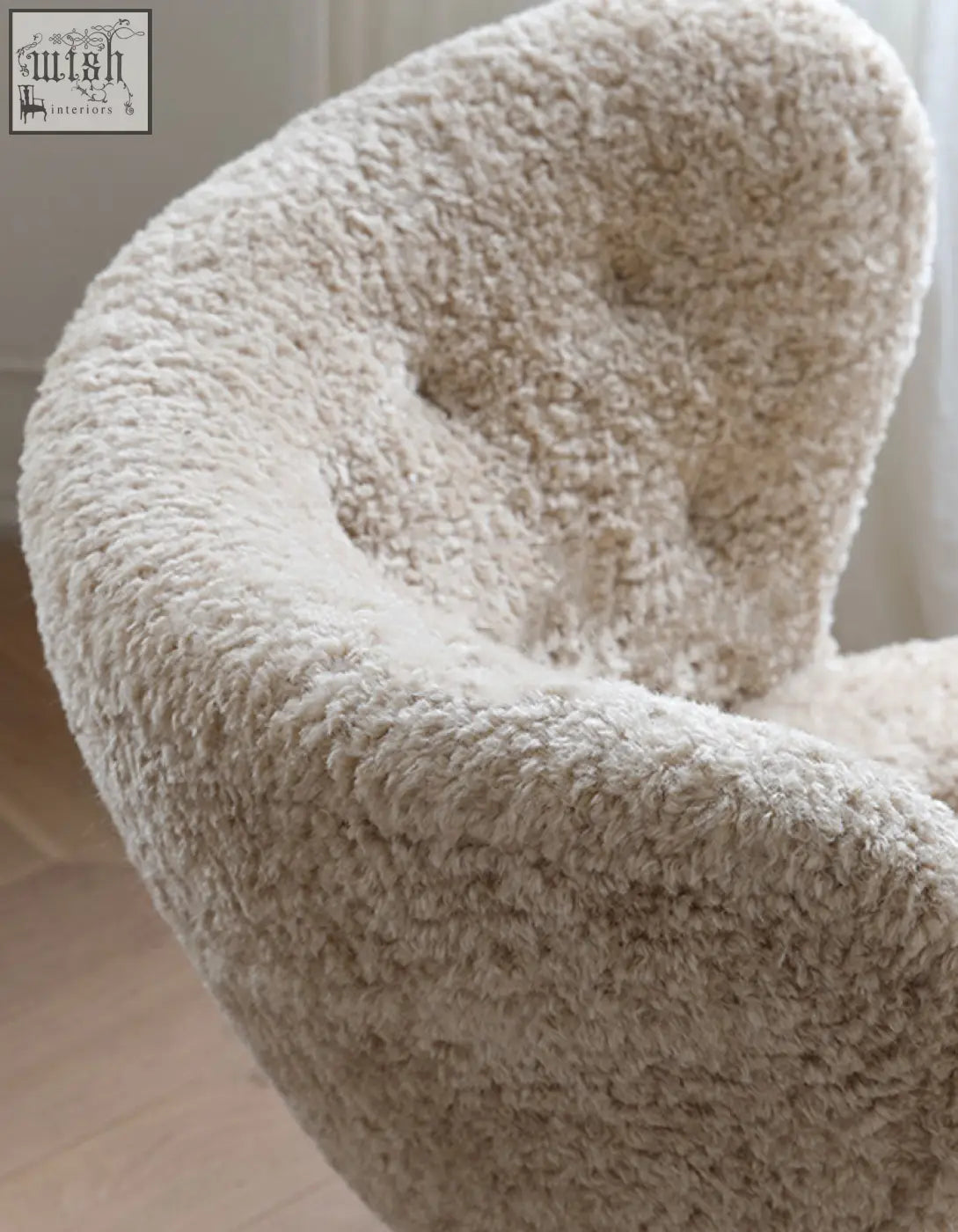 Cream-colored plush fitz armchair made with long hair artificial wool perfect as a cozy lounge chair