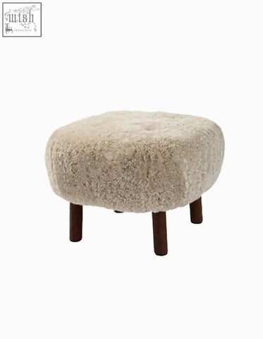 Cream-colored sheepskin ottoman with dark wood legs for fitz armchair lounge chair made with artificial wool