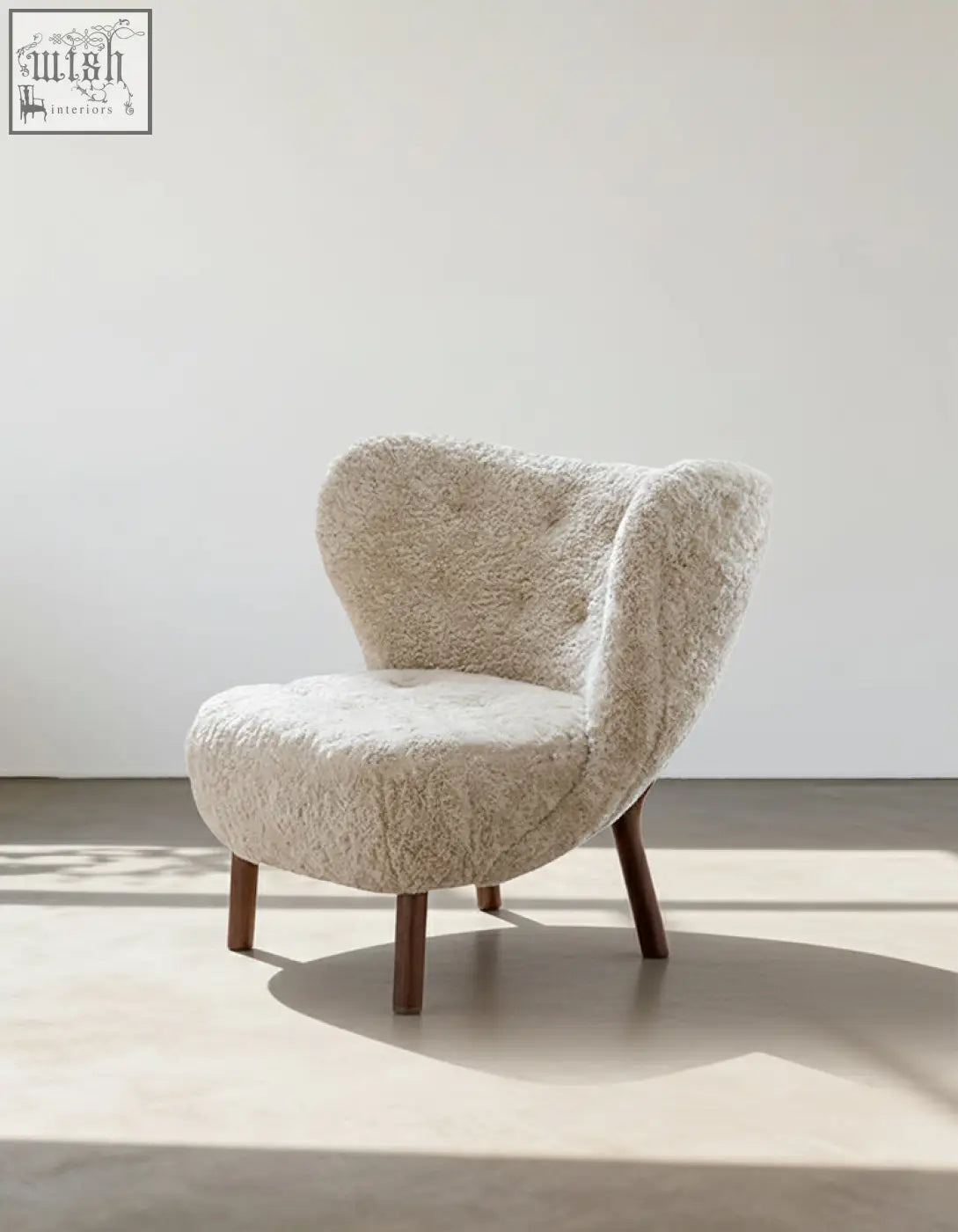 Cream-colored Fitz armchair lounge chair with plush tufted design made from artificial wool and dark wooden legs