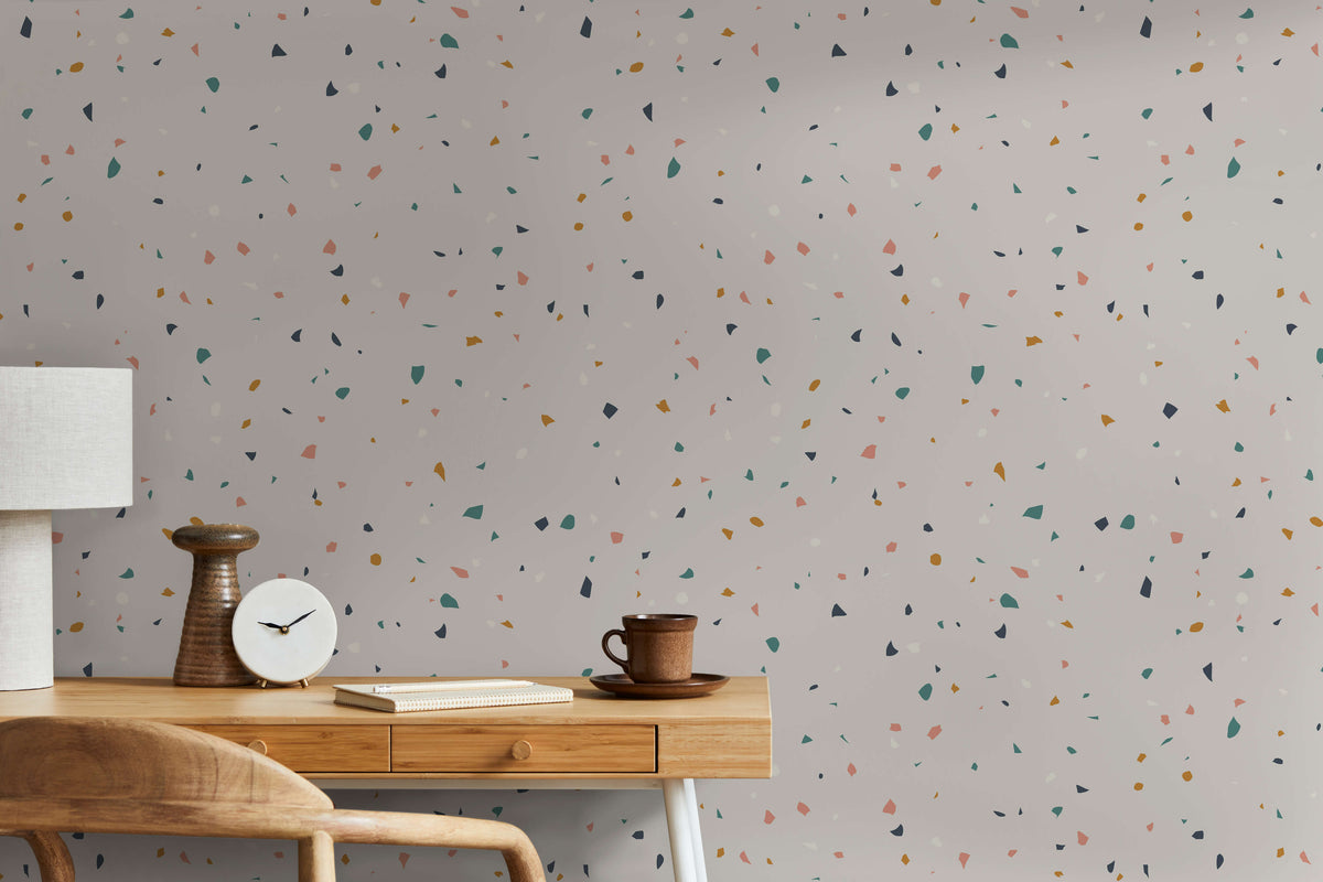 Flake terrazzo-patterned wallpaper with a light gray base and green pink yellow and black specks for stylish walls