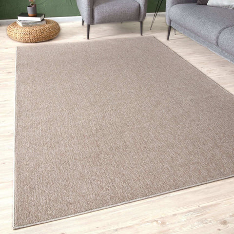 Beige low pile area rug with subtle woven pattern and neatly finished edges perfect for cozy living spaces