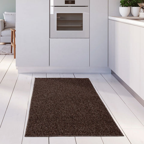 A flex brown low plush rectangular low pile rug with textured surface on white tiled floor