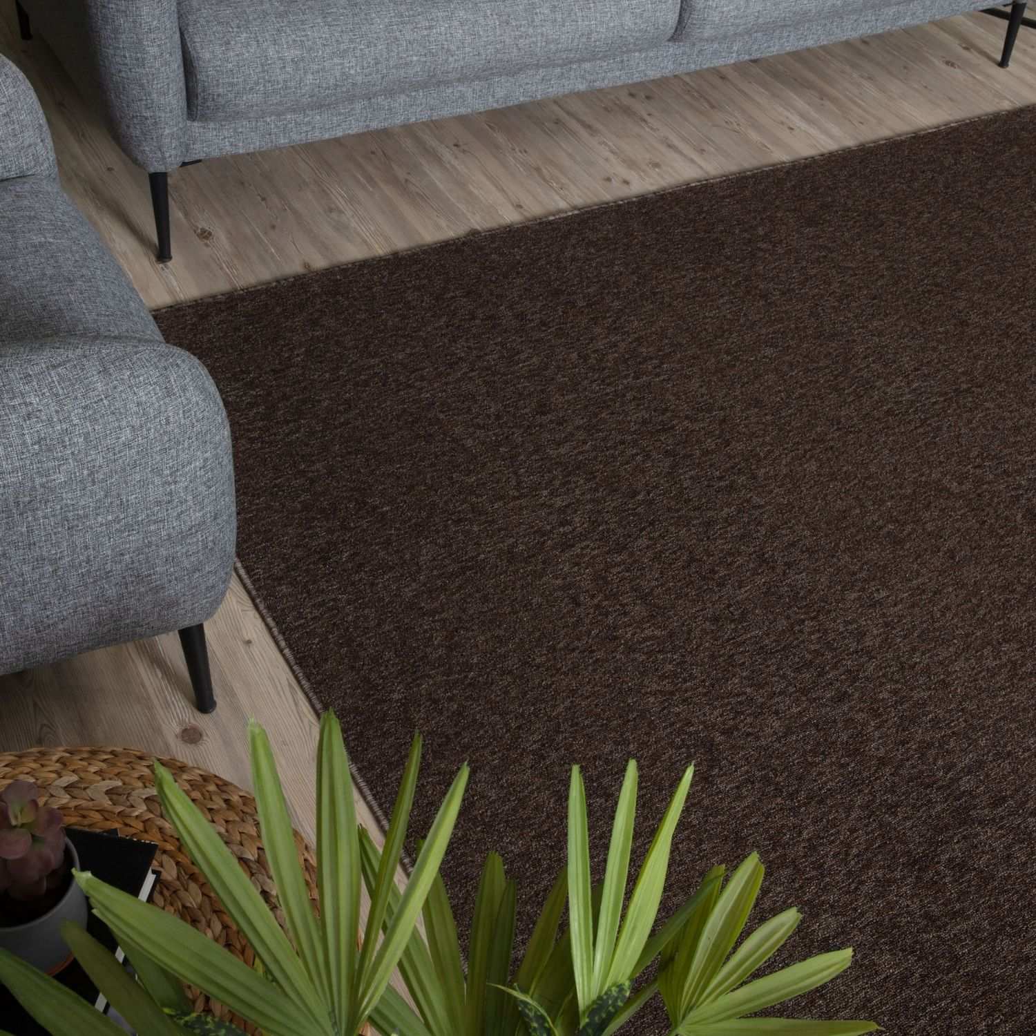 A plush flex brown low pile solid rug with a textured weave lays on a wooden floor perfect for cozy spaces