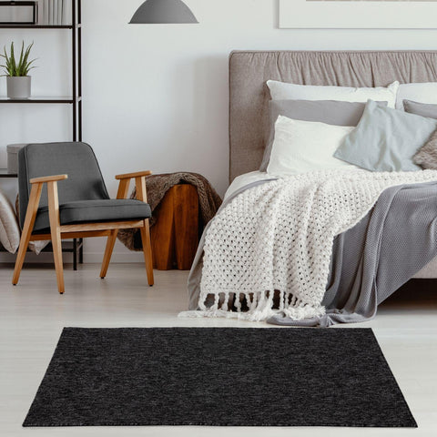 Black textured area rug with a subtle heathered finish in flex dark grey low pile solid style