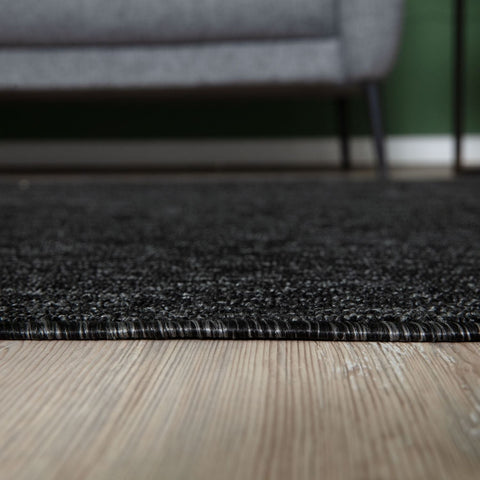 Flex dark grey low pile rug with a dark grey textured surface, subtle speckled pattern, and tightly woven edge