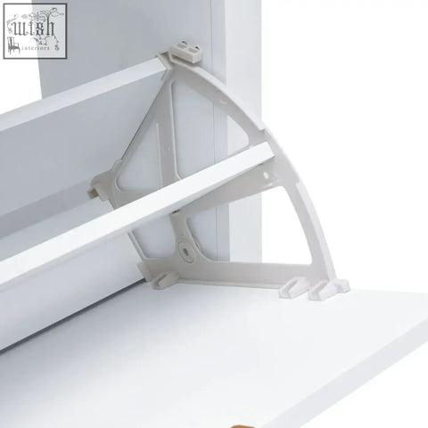 White plastic shelf bracket with triangular design and mounting clips for flip down wood shoe cabinet holding sixteen pairs