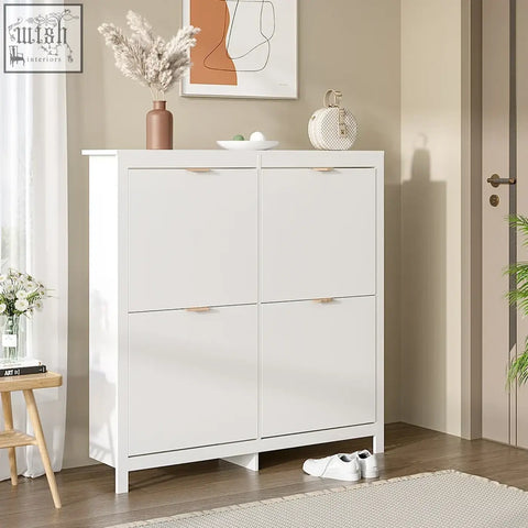 White minimalist wood shoe cabinet with four sliding doors and gold-tone handles holds sixteen pairs of shoes