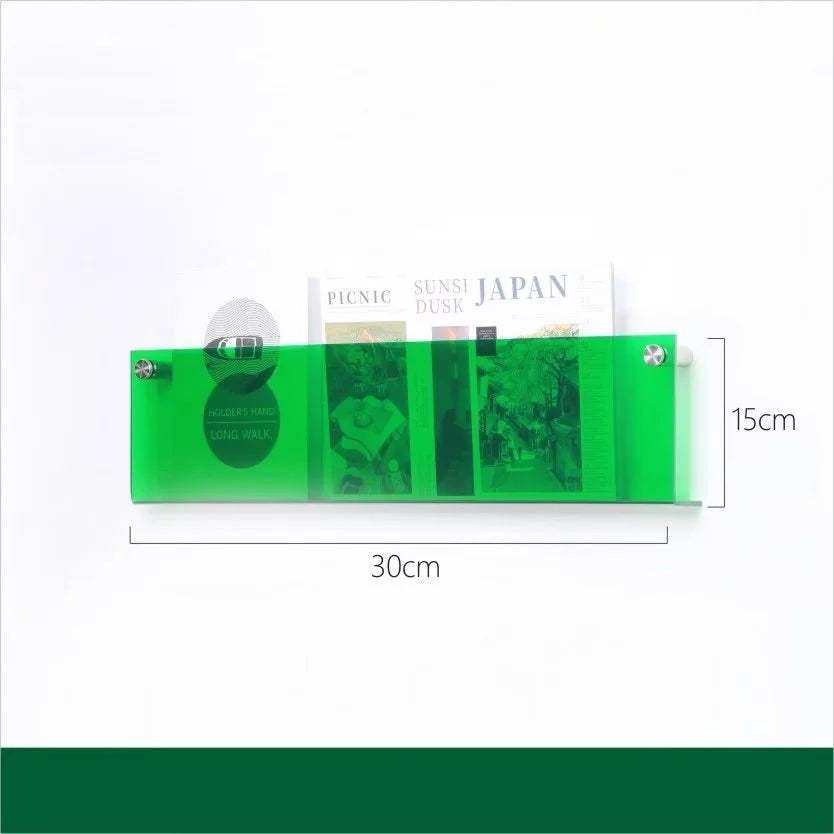 A translucent green floating acrylic magazine holder with three compartments holding different books and magazines