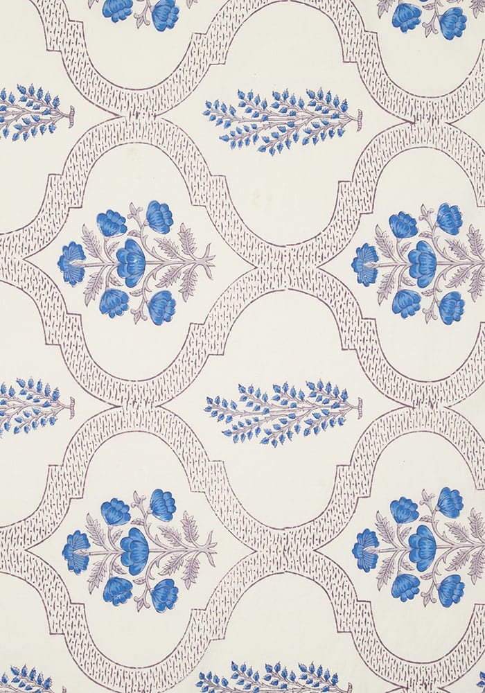 Cream-colored flora blue tablecloth with repeating blue floral motifs inside ornate oval frames pattern