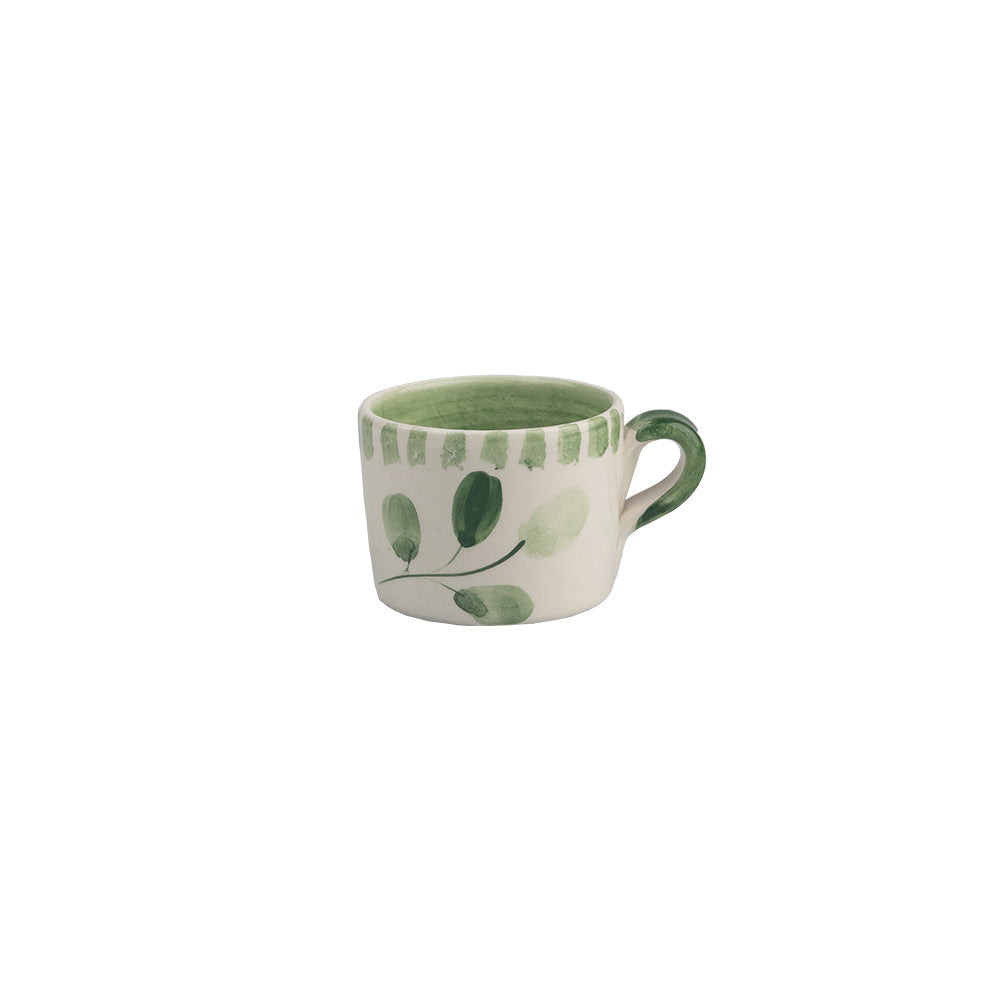 A white ceramic espresso cup with a green handle and interior featuring hand painted green leaf designs