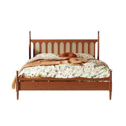 A flora king size bed with a cherry wood frame and cane-backed headboard dressed in floral bedding