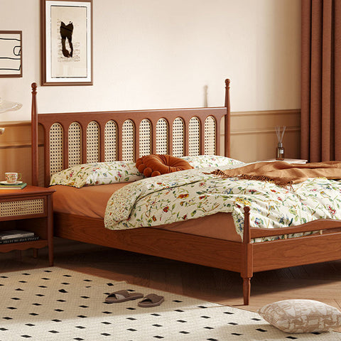 Warm-toned flora king size bed in cherry wood with woven cane headboard and floral-patterned bedding and nightstand