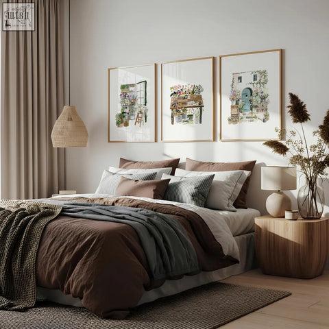 A cozy bed with a brown and gray duvet set and striped pillows, paired with floral art illustrated prints for a country cottage vibe