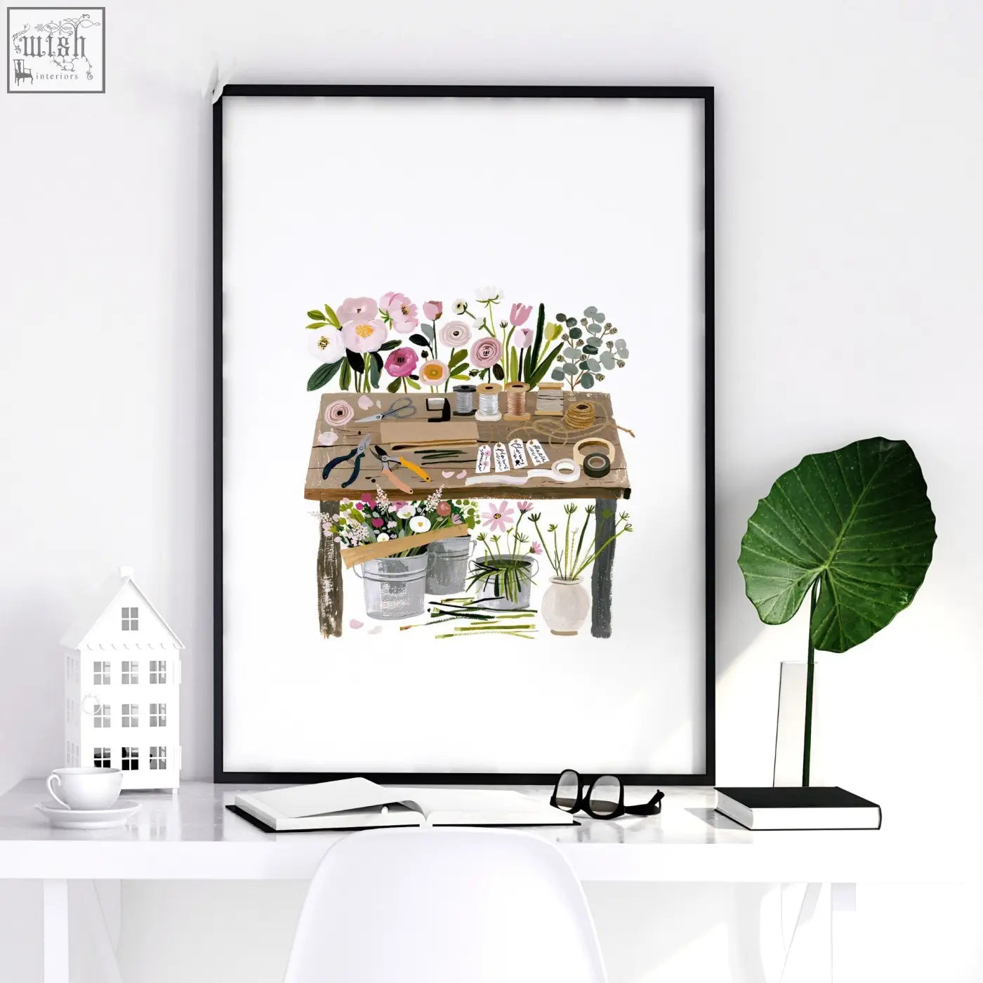 A framed floral art illustrated print set of 3 featuring a rustic wooden table with gardening tools in pastel tones for country cottage decor