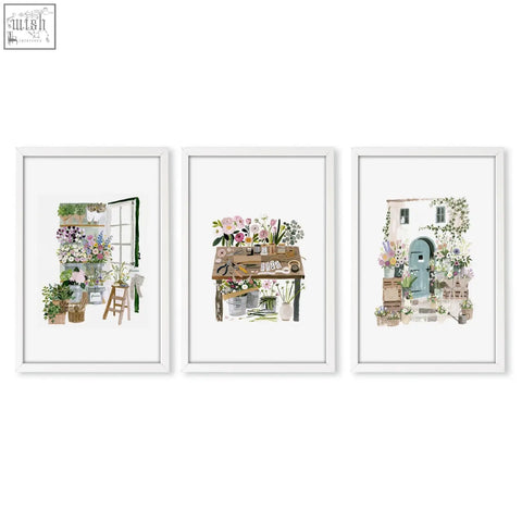 Set of three white-framed floral art illustrated prints featuring country cottage garden scenes for wall decoration