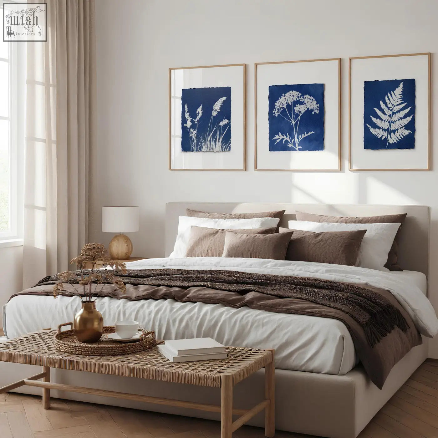 A gold toned ceramic vase with dried botanicals enhancing a floral art wall with indigo botanical prints set of 3