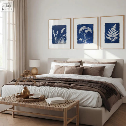 A gold toned ceramic vase with dried botanicals enhancing a floral art wall with indigo botanical prints set of 3