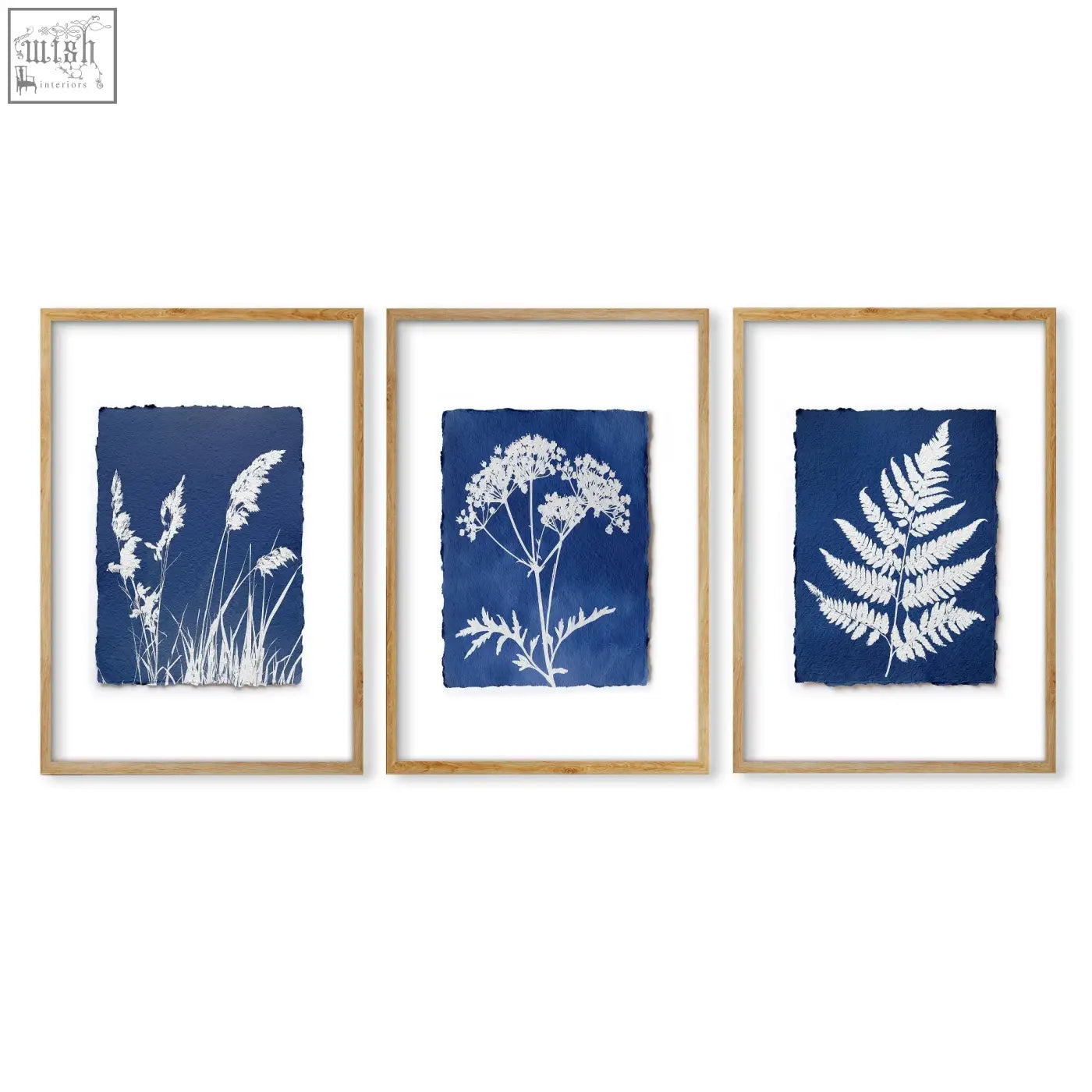 Set of three framed floral art wall cyanotype botanical prints with white silhouettes on deep blue paper in light wood frames